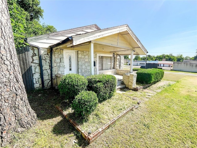 209 SW 40th St, Oklahoma City, OK 73109 - view of front facade with stone siding, a front yard, and covered porch