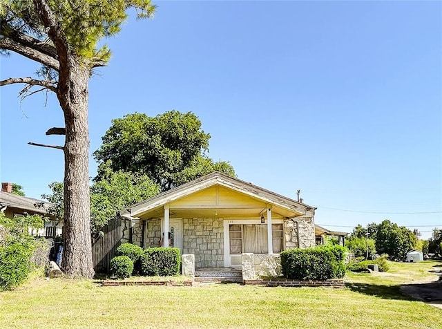 209 SW 40th St, Oklahoma City, OK 73109 - view of front facade featuring stone siding, a front yard, and a porch