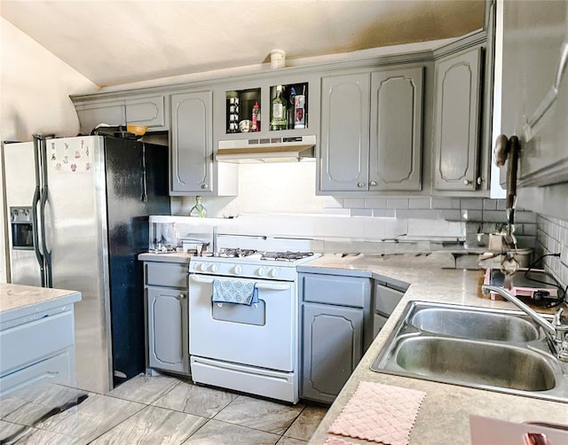 209 SW 40th St, Oklahoma City, OK 73109 - kitchen with white range with gas cooktop, under cabinet range hood, stainless steel fridge with ice dispenser, gray cabinetry, and light countertops