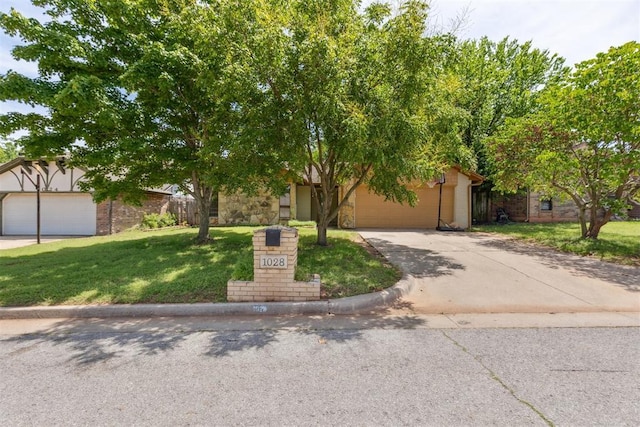 obstructed view of property featuring a front yard, concrete driveway, a garage, and stone siding