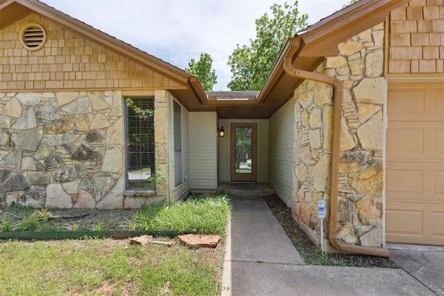 property entrance with stone siding and an attached garage