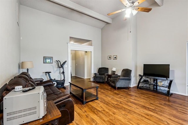 living area with beamed ceiling, ceiling fan, wood finished floors, high vaulted ceiling, and baseboards