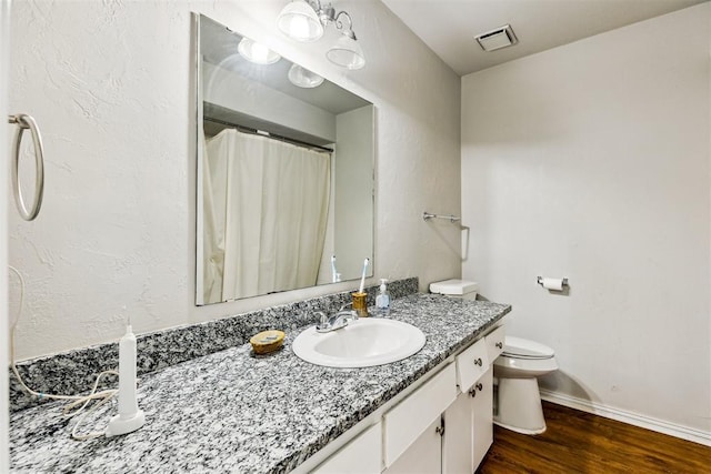 bathroom with wood finished floors, toilet, vanity, baseboards, and a shower with curtain