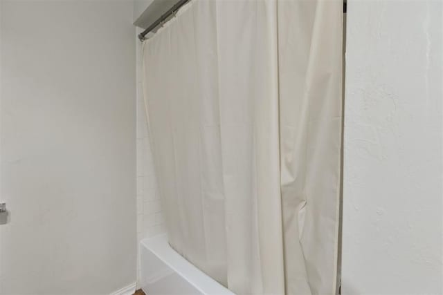 bathroom with baseboards and shower / bath combo