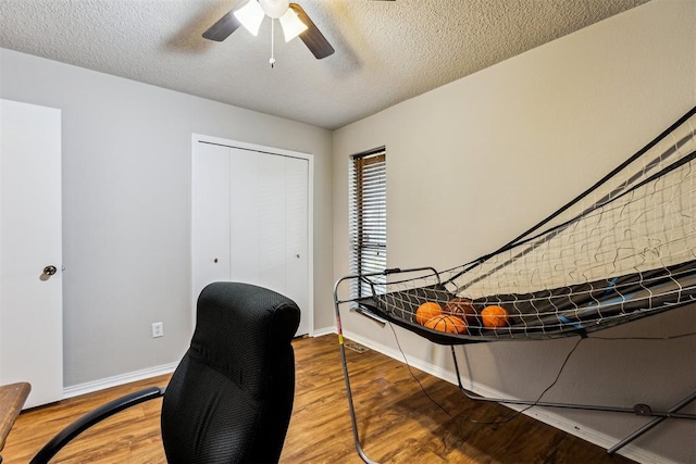 office with wood finished floors, a ceiling fan, baseboards, and a textured ceiling