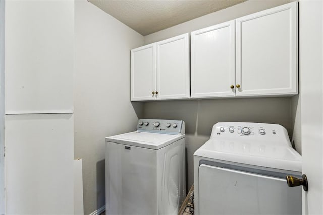 washroom featuring washer and clothes dryer and cabinet space