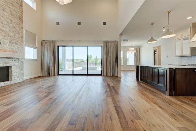 4209 Las Colinas Ln, Norman, OK 73072 - unfurnished living room featuring a high ceiling, light wood-style floors, healthy amount of natural light, a chandelier, and baseboards