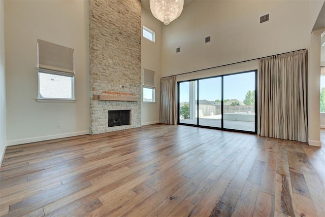 4209 Las Colinas Ln, Norman, OK 73072 - unfurnished living room with a high ceiling, light wood-type flooring, plenty of natural light, baseboards, and a chandelier