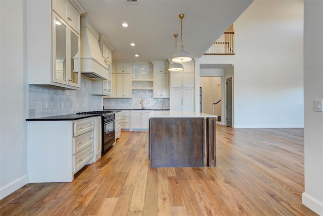 4209 Las Colinas Ln, Norman, OK 73072 - kitchen featuring gas stove, premium range hood, a sink, light wood-type flooring, and baseboards