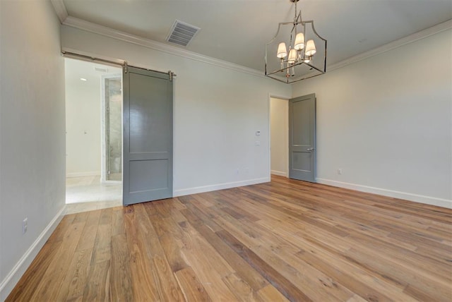 4209 Las Colinas Ln, Norman, OK 73072 - empty room featuring a barn door, crown molding, wood-type flooring, baseboards, and a chandelier