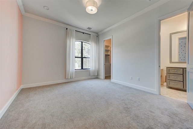 4209 Las Colinas Ln, Norman, OK 73072 - unfurnished bedroom with ornamental molding, light colored carpet, a walk in closet, baseboards, and connected bathroom