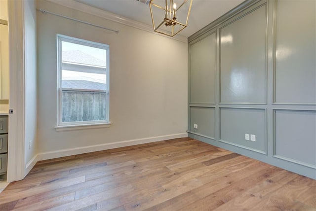 4209 Las Colinas Ln, Norman, OK 73072 - empty room featuring a chandelier, baseboards, light wood-style flooring, and crown molding