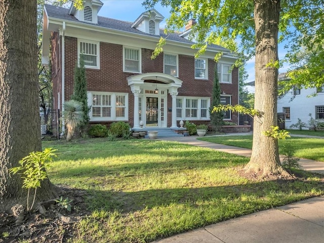 1223 NW 20th St, Oklahoma City, OK 73106 - colonial inspired home with brick siding, a front yard, and a chimney