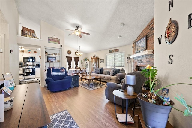 6104 Westlane, Oklahoma City, OK 73142 - living area featuring a textured ceiling, lofted ceiling, ceiling fan, built in shelves, and wood finished floors