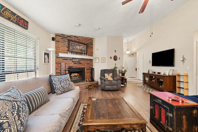 6104 Westlane, Oklahoma City, OK 73142 - living room featuring a fireplace, wood finished floors, a ceiling fan, and a textured ceiling