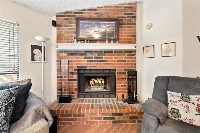 6104 Westlane, Oklahoma City, OK 73142 - living room featuring a fireplace, vaulted ceiling, wood finished floors, and a textured ceiling