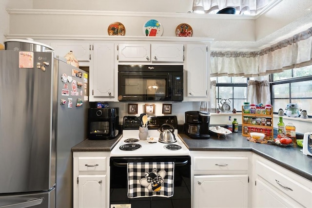6104 Westlane, Oklahoma City, OK 73142 - kitchen with freestanding refrigerator, black microwave, electric stove, dark countertops, and white cabinetry