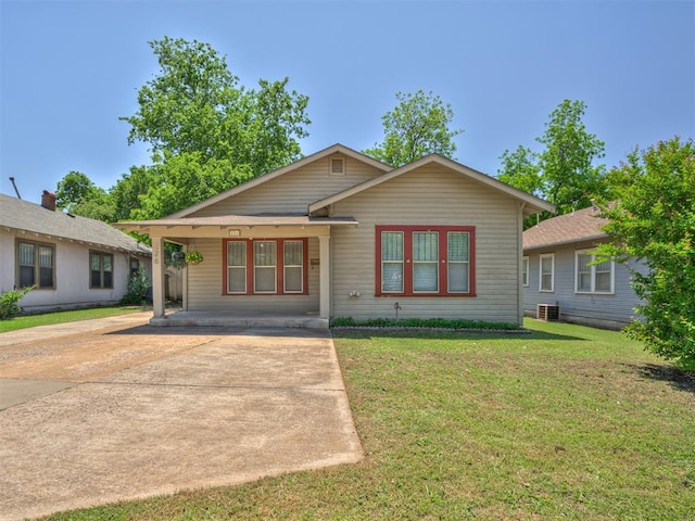 view of front of house with a front lawn, a porch, driveway, and central AC