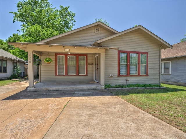 bungalow with a front lawn and covered porch