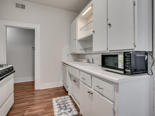 kitchen with open shelves, a sink, wood finished floors, baseboards, and white cabinets