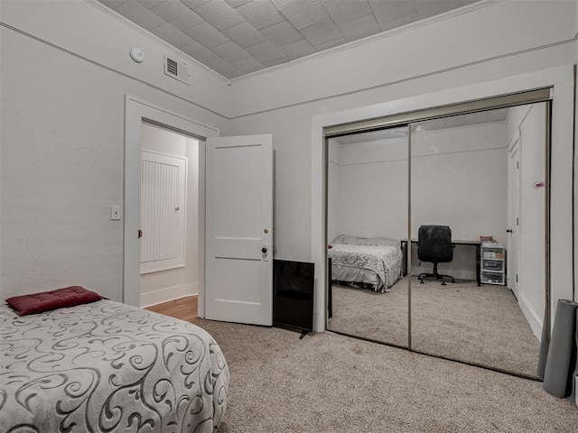 bedroom featuring a closet, carpet floors, and crown molding