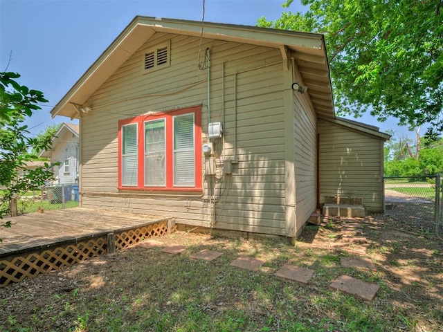 view of side of home featuring a deck and fence