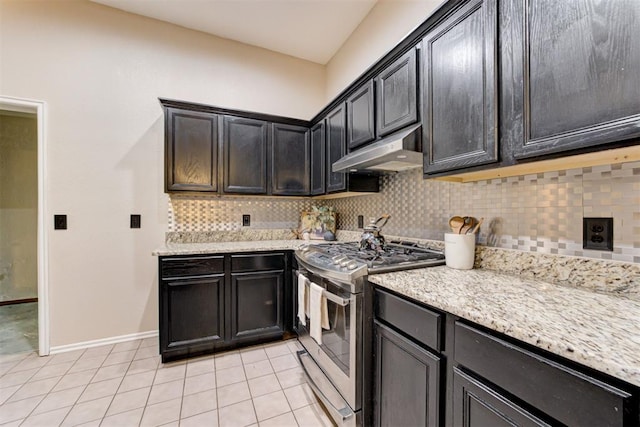 619 Rimrock Rd, Edmond, OK 73034 - kitchen featuring under cabinet range hood, stainless steel gas range oven, light tile patterned floors, and decorative backsplash