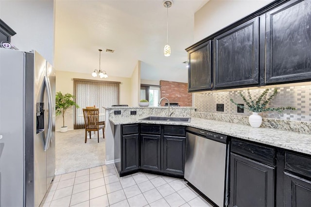 619 Rimrock Rd, Edmond, OK 73034 - kitchen featuring appliances with stainless steel finishes, a sink, a peninsula, light tile patterned floors, and backsplash