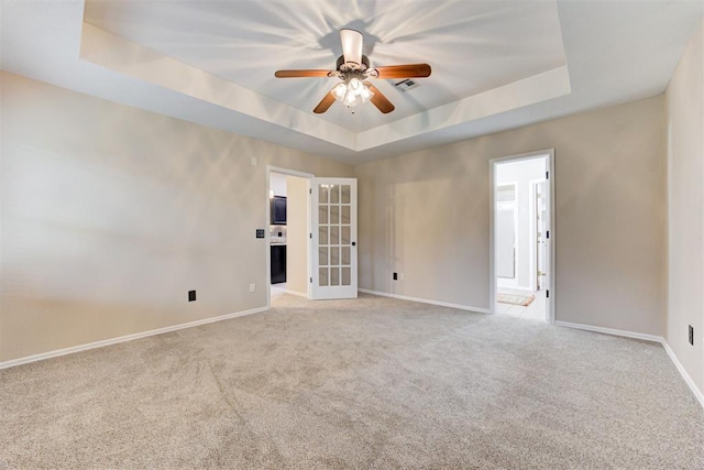 619 Rimrock Rd, Edmond, OK 73034 - empty room featuring a raised ceiling, baseboards, light colored carpet, a ceiling fan, and french doors