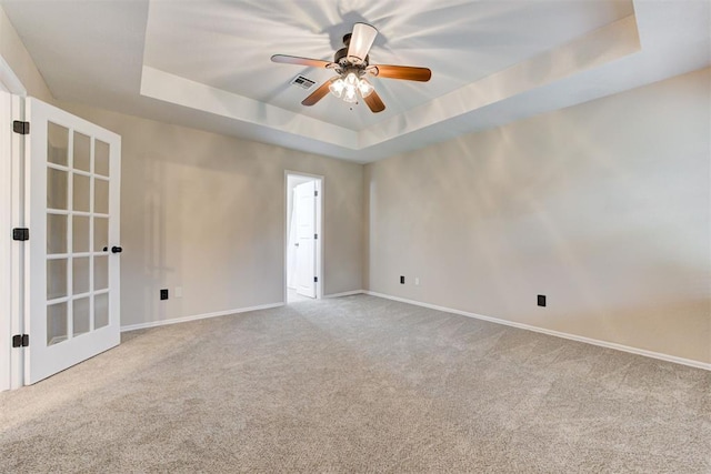 619 Rimrock Rd, Edmond, OK 73034 - spare room featuring a raised ceiling, carpet, baseboards, and a ceiling fan
