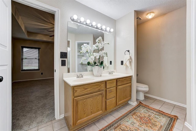 619 Rimrock Rd, Edmond, OK 73034 - bathroom with tile patterned floors, double vanity, toilet, and baseboards