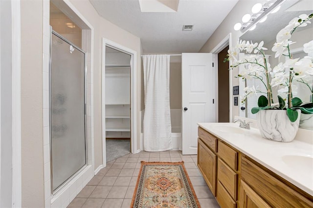 619 Rimrock Rd, Edmond, OK 73034 - bathroom with a shower stall, double vanity, tile patterned floors, and a walk in closet