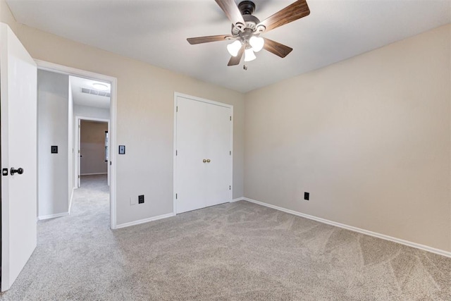 619 Rimrock Rd, Edmond, OK 73034 - unfurnished bedroom with light colored carpet, baseboards, and a ceiling fan