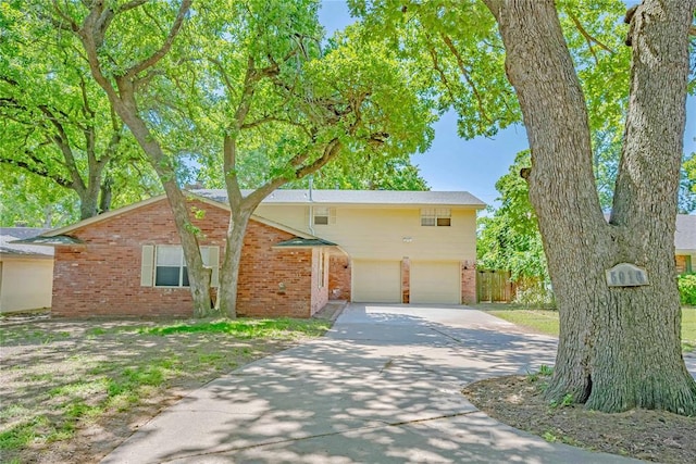 5016 NW 26th St, Oklahoma City, OK 73127 - view of front of house with concrete driveway, an attached garage, brick siding, and fence