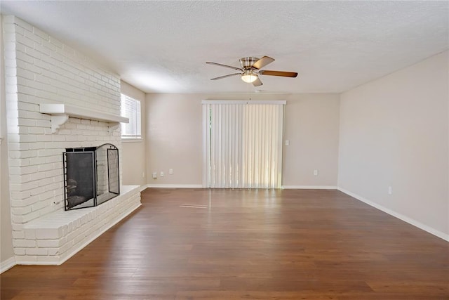 5016 NW 26th St, Oklahoma City, OK 73127 - unfurnished living room featuring ceiling fan, a fireplace, wood finished floors, baseboards, and a textured ceiling
