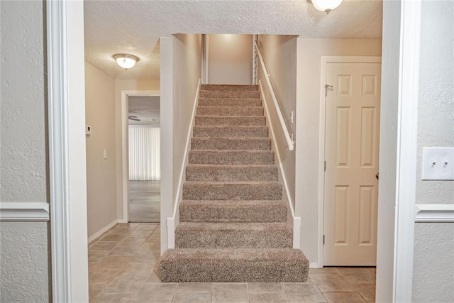 5016 NW 26th St, Oklahoma City, OK 73127 - staircase featuring a textured ceiling, a textured wall, tile patterned floors, and baseboards