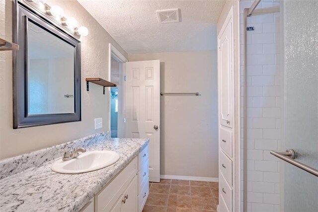 5016 NW 26th St, Oklahoma City, OK 73127 - full bath with a textured ceiling, vanity, tiled shower, and tile patterned flooring