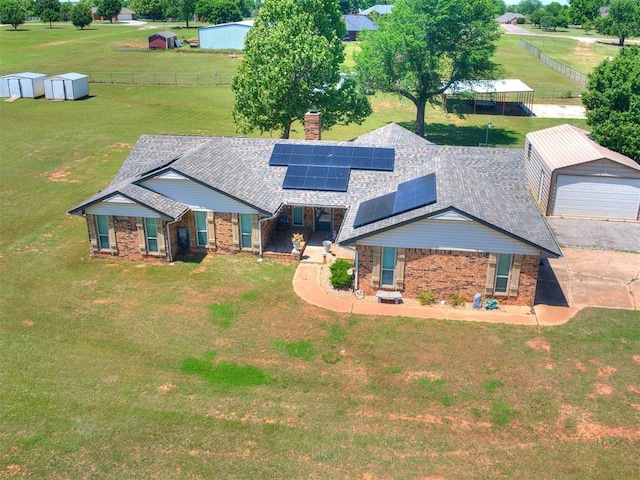 764 S Sara Rd, Tuttle, OK 73089 - view of front of home featuring an outdoor structure, brick siding, a chimney, solar panels, and roof with shingles
