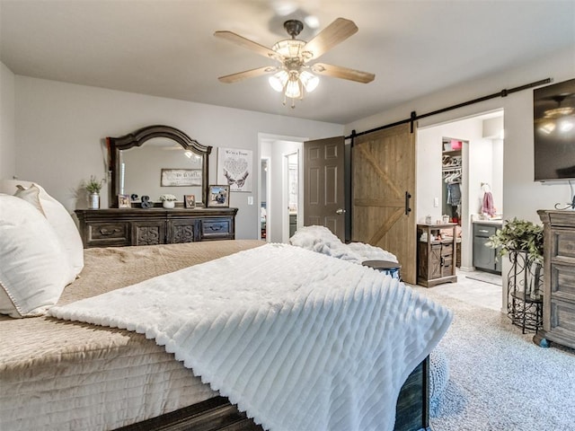 764 S Sara Rd, Tuttle, OK 73089 - bedroom with a barn door, carpet flooring, ceiling fan, and a walk in closet