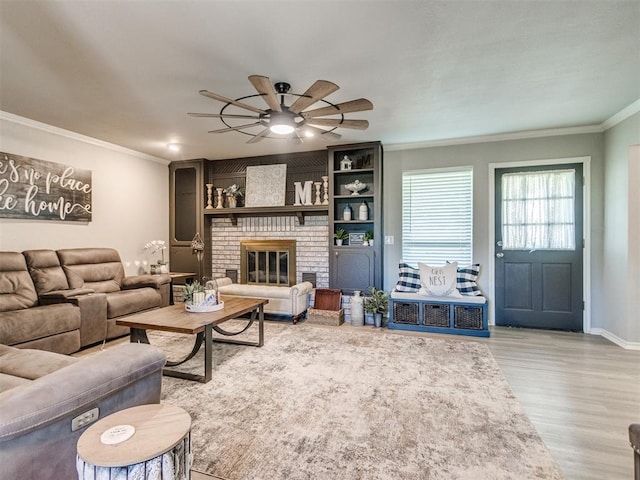764 S Sara Rd, Tuttle, OK 73089 - living room with crown molding, wood finished floors, ceiling fan, baseboards, and a brick fireplace