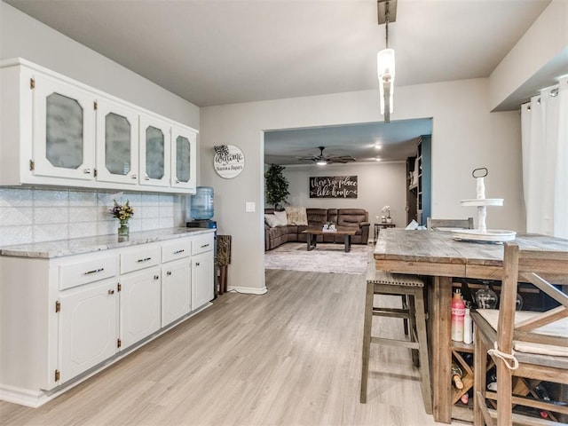 764 S Sara Rd, Tuttle, OK 73089 - kitchen with light wood-style flooring, white cabinets, decorative backsplash, and ceiling fan