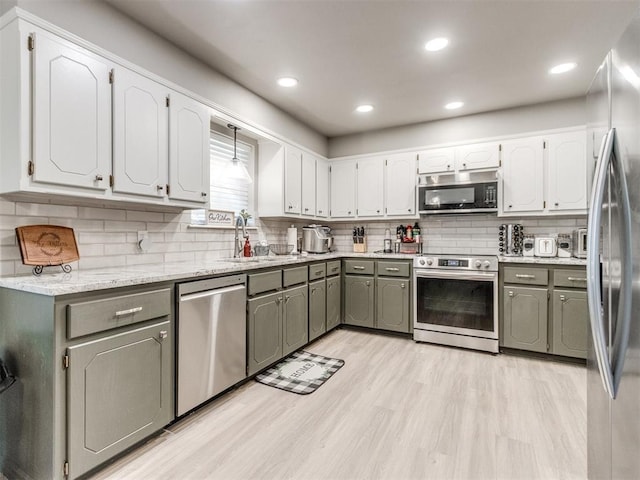 764 S Sara Rd, Tuttle, OK 73089 - kitchen featuring stainless steel appliances, a sink, gray cabinets, light wood finished floors, and tasteful backsplash