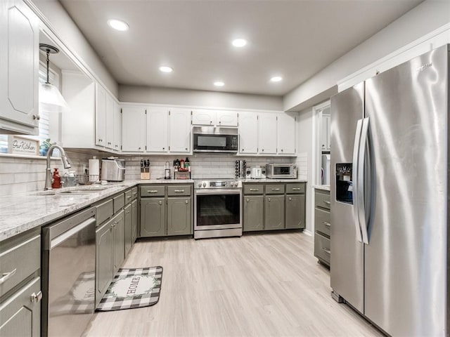 764 S Sara Rd, Tuttle, OK 73089 - kitchen featuring stainless steel appliances, a sink, gray cabinets, light wood-type flooring, and white cabinets