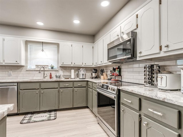 764 S Sara Rd, Tuttle, OK 73089 - kitchen featuring appliances with stainless steel finishes, a sink, gray cabinets, tasteful backsplash, and white cabinetry