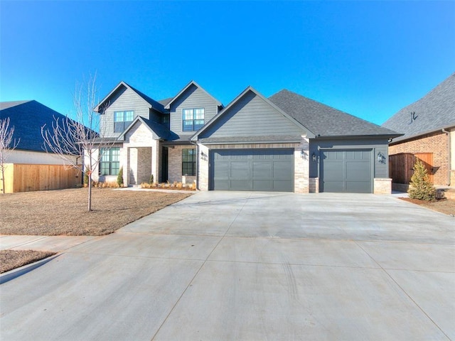 4405 Las Colinas Ln, Norman, OK 73072 - view of front of house featuring an attached garage, concrete driveway, stone siding, and fence