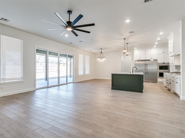 4405 Las Colinas Ln, Norman, OK 73072 - unfurnished living room with ceiling fan, a chandelier, light wood-style floors, and recessed lighting