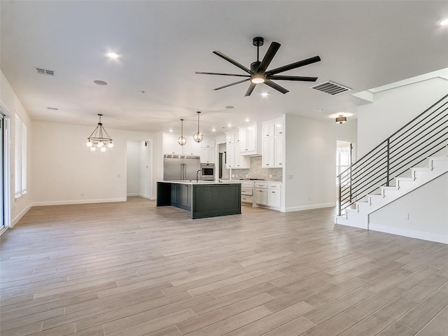 4405 Las Colinas Ln, Norman, OK 73072 - unfurnished living room with a chandelier, a ceiling fan, light wood finished floors, baseboards, and recessed lighting