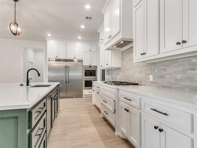 4405 Las Colinas Ln, Norman, OK 73072 - kitchen with appliances with stainless steel finishes, a sink, white cabinetry, decorative backsplash, and light countertops