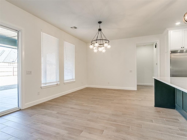4405 Las Colinas Ln, Norman, OK 73072 - unfurnished dining area with light wood-type flooring, a chandelier, and baseboards