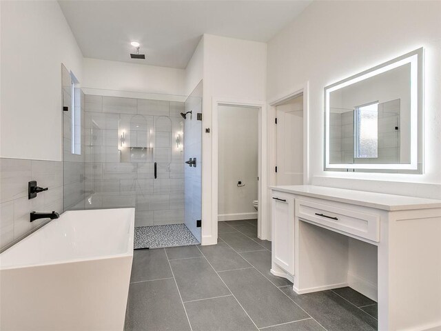 4405 Las Colinas Ln, Norman, OK 73072 - bathroom featuring a stall shower, toilet, tile patterned flooring, and a soaking tub